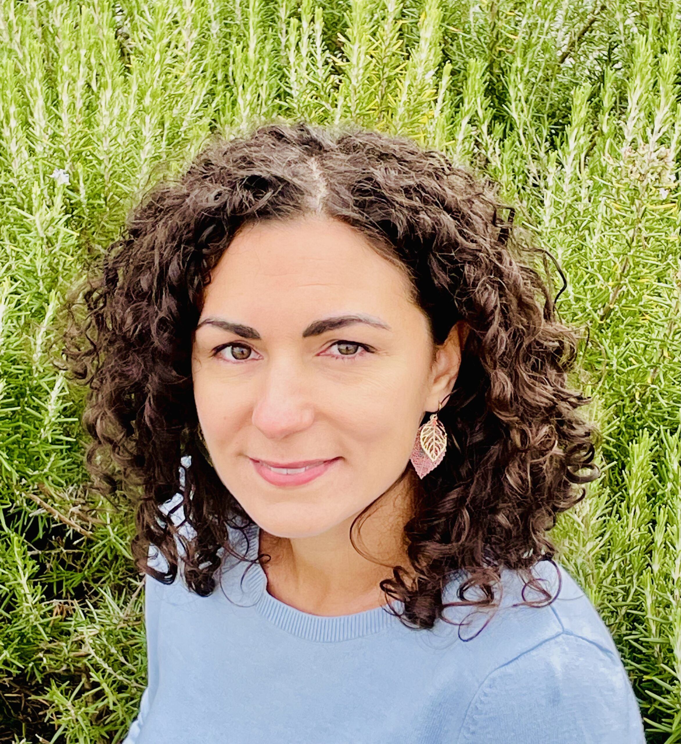 Photo of woman smiling in front of plants